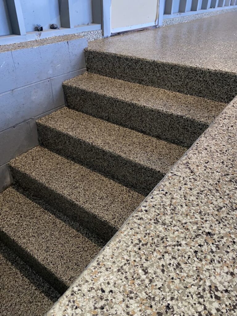 A set of short terrazzo steps leads to a wall, with a barred window above. No landmarks or historical buildings visible.